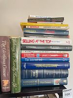 Stack of horizontally piled hardcovers and paperbacks showing spines of Chaos, Selling at the Top, Lessons, X-Engineering the Corporation, True Compass etc.