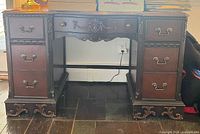 Front view of mahogany pedestal desk with all drawers closed