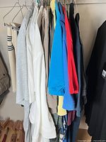 Group of hanging shirts and sweaters on rack