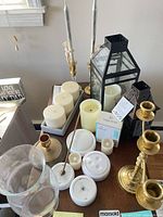 Group view showing brass candlesticks, lanterns, hurricane vase, pillar candles, Vekkia LED tea lights