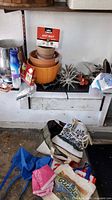 Shelf with ant bait, pots, star-wheel cultivators, gloves and tote bags