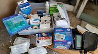 Overall view of bin contents including monitor, wipes, tapes, alcohol pads, bandages