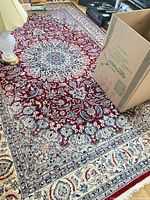 Full view showing red field, blue/ivory border, overall pattern and fringe