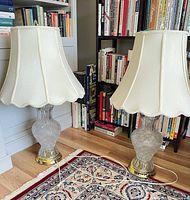 Both crystal lamps with shades on floor near bookcase