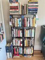 Front view of both narrow ladder-style bookcases filled with books