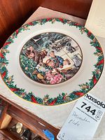 Front view of porcelain plate showing Christmas scene and garland border
