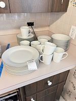 Stacks of plates, bowls and mugs showing overall lot