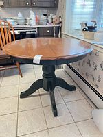 Full view of round dining table showing top and black pedestal base
