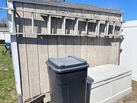 Deck box and trash can against shed