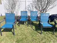Four blue metal frame mesh patio chairs on lawn