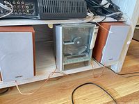 Stereo main unit centered between two matching Sony bookshelf speakers, wires visible