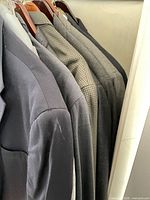 Row of assorted suit jackets on hangers showing colours and quantity