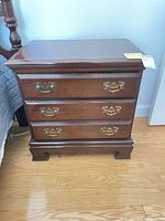 Front view of nightstand showing three drawers and hardware