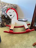 Left side view of red, white and black wooden rocking horse