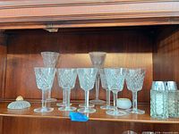 Shelf with Waterford wine glasses, champagne flutes, pressed-glass shakers, crystal lid and porcelain dish