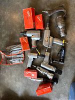 Assorted Snap-on pneumatic tools and socket boxes on floor