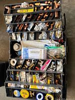 Overall view of open toolbox showing organised trays filled with copper, brass fittings, tapes, compounds