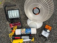 Group shot showing heater, halogen light, LED light, rolled mat, and other tools
