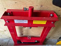 Front view of red hydraulic floor press frame