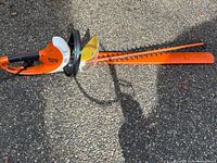 Stihl HSE 70 hedge trimmer with blade guard on pavement