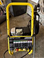 Front view of Karcher pressure washer showing frame, control panel, hose and gun