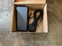 Pedal in box showing textured top and cable with connector
