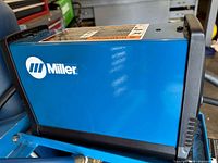 Left side view of Miller Spectrum 375 X-TREME plasma cutter showing blue housing and logo