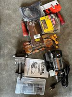 Assortment of packaged Oregon tools, loose chain, red-handled files, grinder manual visible