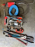assorted plumbing and electrical tools laid out on floor