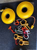 Two yellow Cordpro reels with orange cords and assorted plastic cable clamps on black mat