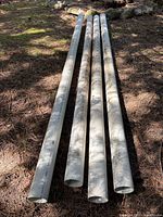 Four 10 ft PVC pipes lying on ground