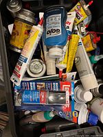 Top view of tub with assorted tubes, GoJo bottle and metal cans