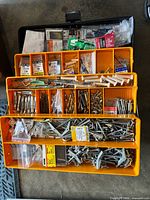 Top view of open organizer showing trays full of assorted anchors and screws