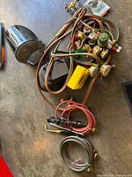 Overall lot view with hoses, torches, regulators, welding helmet, face shield