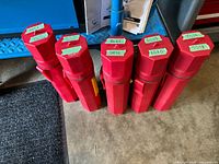 Six red electrode canisters standing upright with green labels showing electrode types