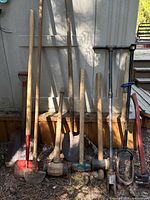 Full group of yard tools leaning against shed