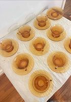 Overhead view showing full set of amber glass cups and saucers