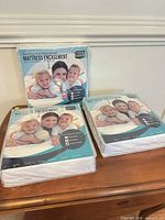 Front view of three sealed Utopia Bedding mattress encasements