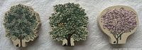 Front view of three Cat's Meow Village wooden tree collectibles