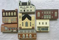 All seven Cat's Meow wooden building pieces arranged on cloth background