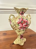 Front view of ornate ceramic vase showing floral design and gold accents