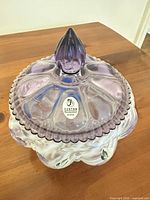 Top view showing amethyst lid with finial and Fenton sticker