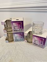 Three Anchor Hocking Tartan glass sets, boxes stacked with two loose glasses displayed