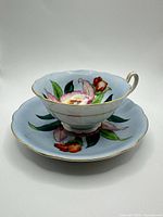 Teacup on saucer showing floral design and gold trim