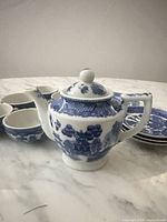 Miniature teapot front with cups and saucers