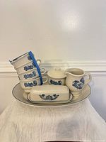 Full set stacked on platter showing mugs, butter dish, sugar bowl, creamer, tray