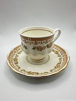 Front view of cup on saucer showing floral pattern and gold trim