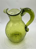 Front view of green crackle glass pitcher vase