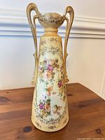 Front view of ceramic vase showing floral design and handles