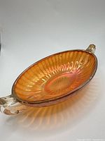 Top view of marigold carnival glass oval dish showing ribbed interior and handles